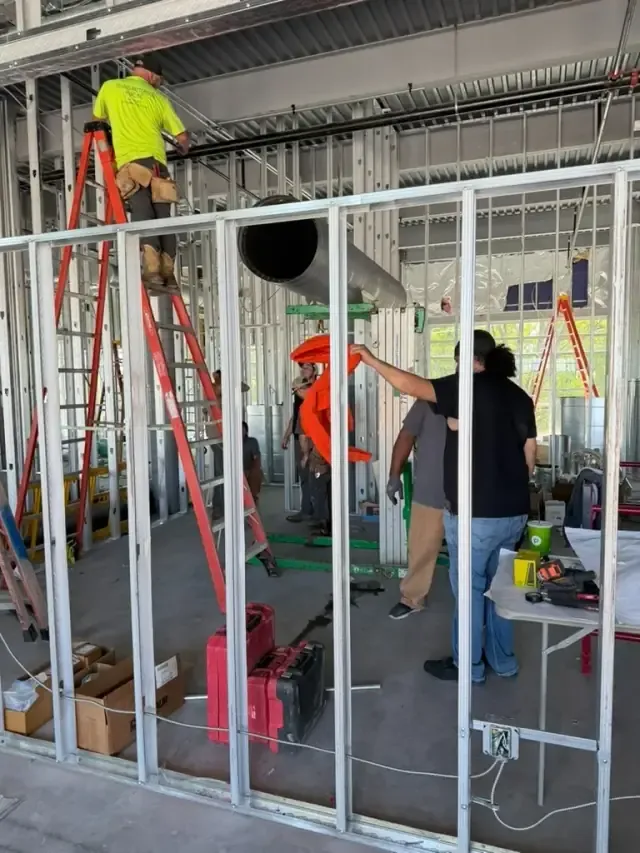 Interior of the studio mid-buildout with framed walls and construction materials throughout the space.