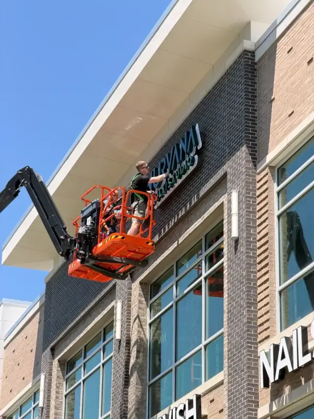 The Nurvana Multistudio exterior sign being installed above the storefront.